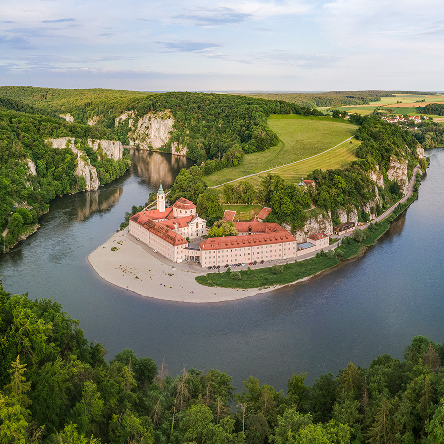 Luftaufnahme des Klosters Weltenburg in der Donauschleife im Altmühltal, umgeben von Felsen, Wäldern und der Donau