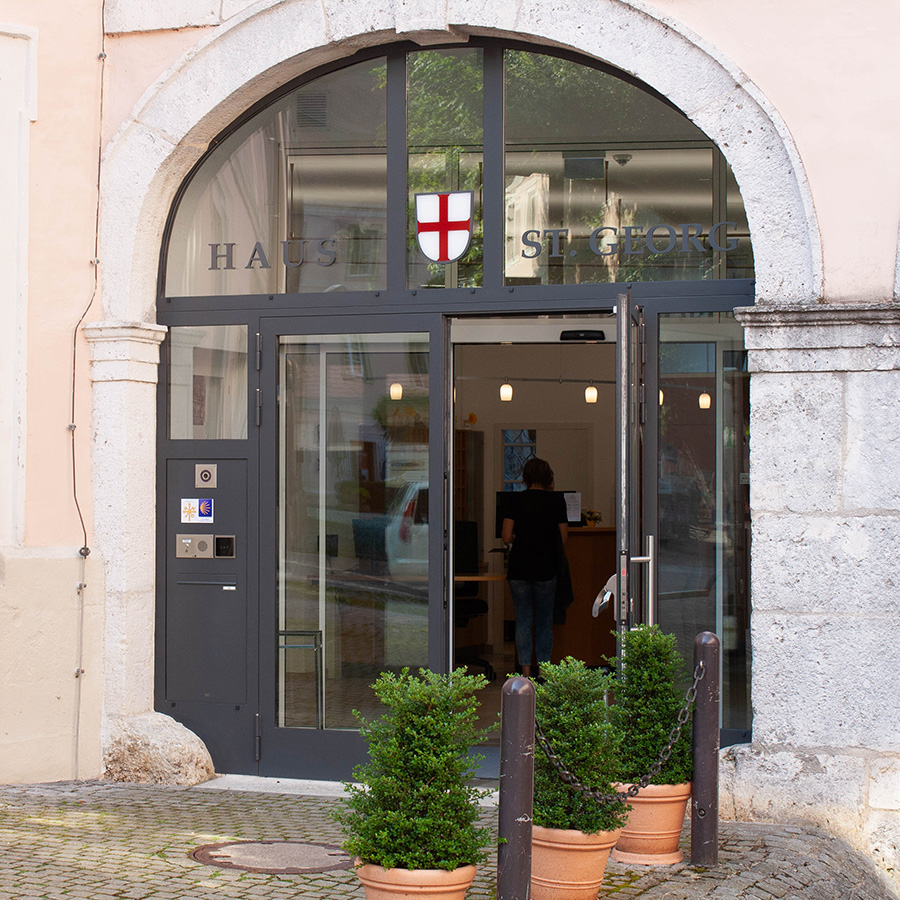 Eingang des Gästehauses St. Georg mit Glasportal und Rezeption drinen