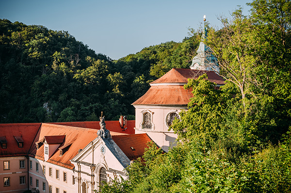 Kloster Weltenburg mit Klosterkirche St. Georg, umgeben von bewaldeten Felsen der Weltenburger Enge