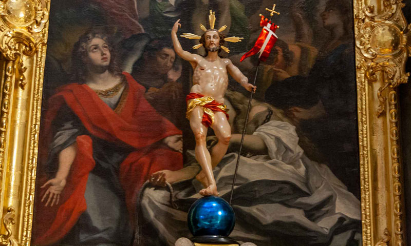 Religiöse Darstellung von Jesus als Auferstandener mit Fahne vor barockem Altarbild.