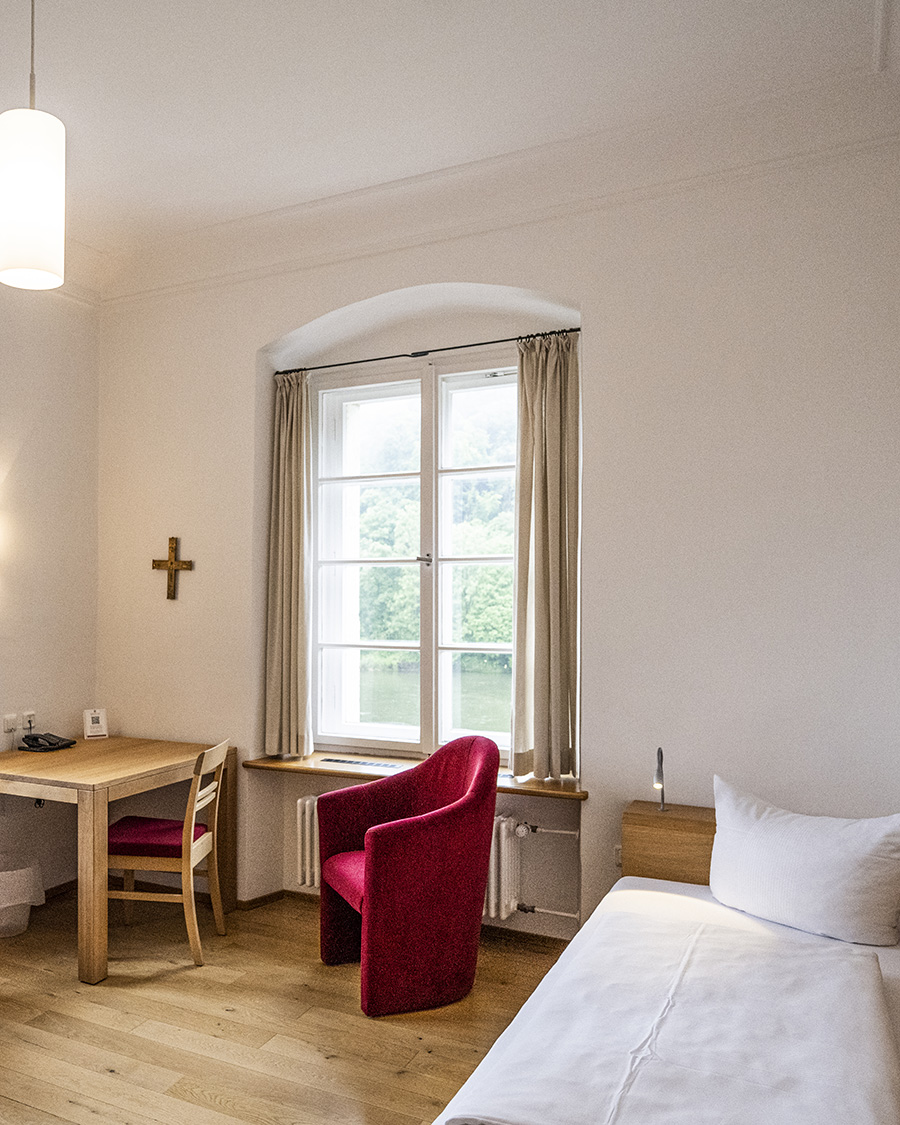 Zimmer mit zwei Einzelbetten und zwei roten Hockern im Gästehaus St.Georg
